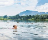 Chica nadando en el lago, Fuessen, Baviera, Alemania - foto de stock