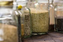 Pots de quinoa, tournesol et graines de lin sur la table — Photo de stock