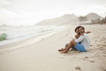 Couple assis sur la plage, Rio De Janeiro, Brésil — Photo de stock
