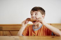 Giovane ragazzo mangiare pezzo di pane tostato — Foto stock