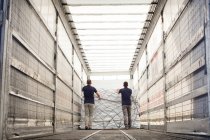 Workers pushing freight in air freight container — Stock Photo