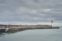 Persone che pescano sul muro del porto lontano, Cumbria, Regno Unito — Foto stock