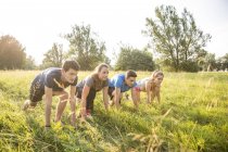 Group of friends in field, in starting position, about to race — Stock Photo