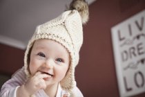 Portrait of smiling baby girl in knitted hat — Stock Photo