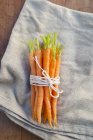 Букет з свіжої морквою взяв зв'язали мотузкою на тканину для серветок — стокове фото