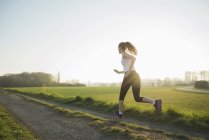 Молода жінка бігунка на трасі — стокове фото