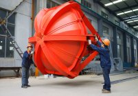 Trabajadores que trabajan juntos en instalaciones de fabricación de grúas, China - foto de stock