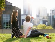 Junges Paar macht Kaffeepause auf Gras, Melbourne, Victoria, Australien — Stockfoto