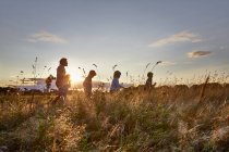 Une famille se promène dans le parc au coucher du soleil — Photo de stock