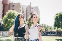 Two young women looking sideways in urban park — Stock Photo
