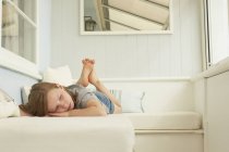 Sullen fille couché sur siège appartement de vacances — Photo de stock