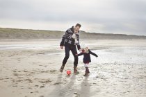 Homem adulto médio com filha jogando futebol na praia, Bloemendaal aan Zee, Países Baixos — Fotografia de Stock