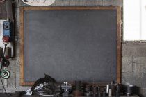 Tableau noir vierge, outils et tubes en atelier — Photo de stock