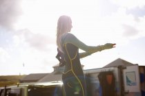 Female surfer putting on wetsuit — Stock Photo