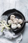 Чесночные луковицы в сковороде с зеленым луком — стоковое фото