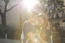 Giovane coppia che si abbraccia sulla strada suburbana — Foto stock