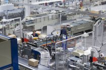 Lavoratrici e lavoratrici che lavorano in una fabbrica di imballaggi di carta — Foto stock