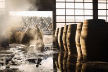Male cooper working in cooperage with whisky casks — Stock Photo