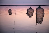 Silhouette delle reti da pesca sull'acqua ferma — Foto stock