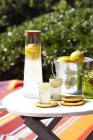 Refrigerante de Limoncello em garrafa de vidro e balde de gelo de limões na mesa — Fotografia de Stock