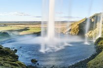 Мальовничі краєвиди позаду тече водоспад Seljalandsfoss, Ісландія — стокове фото