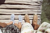 Personal perspective of couples feet standing on wooden bridge, Plitvice Lakes National Park, Croatia — Stock Photo