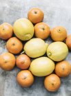 Vista superior de mandarinas maduras y limones sobre la mesa - foto de stock
