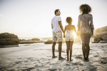 Genitori e figlia si godono la spiaggia al tramonto — Foto stock