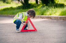 Boy playing traffic worker on rural road — Stock Photo