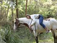 Retrato de adolescente menina abraçando cavalo enquanto bareback equitação — Fotografia de Stock