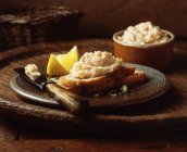 Рибний паштет на нарізаному хлібі з лимонним шматочком — стокове фото