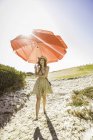 Mid adult woman carrying beach umbrella at beach, Cape Town, South Africa — Stock Photo