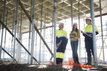 Site manager and architects chatting on construction site — Stock Photo