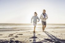 Father and son walking on beach — Stock Photo