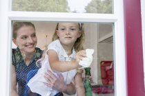 Mother and daughter cleaning window — Stock Photo