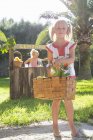 Retrato de menina carregando cesta de limões na frente do quiosque de limonada — Fotografia de Stock