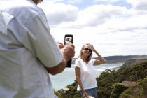 Ehemann fotografiert Ehefrau, Ozean im Hintergrund, Raglan, Neuseeland — Stockfoto