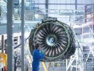 Engineer inspecting jet engine in aircraft maintenance factory — Stock Photo