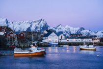 Reine village de pêcheurs au crépuscule avec des montagnes enneigées, Norvège — Photo de stock
