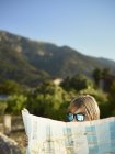 Мальчик в солнечных очках, глядя на карту, Мальорка, Испания — стоковое фото