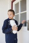 Мальчик несет стопку чашек на патио — стоковое фото