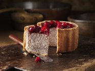Cranberry topped pork pie on chopping board — Stock Photo