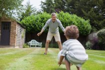 Avô e neto brincando com futebol no jardim — Fotografia de Stock