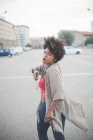 Junge Frau läuft und tanzt zu Kopfhörermusik auf Stadtparkplatz — Stockfoto