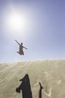 Jovem mulher pulando no ar, Dune de Pilat, França — Fotografia de Stock