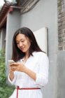 Молодая азиатка смотрит на мобильный телефон — стоковое фото