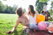 Young couple flirting at park party — Stock Photo