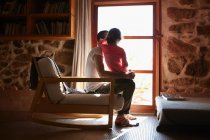 Mittlerer Erwachsener Mann und Tochter schauen aus dem Fenster — Stockfoto