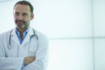 Doctor posing against backlit wall panel — Stock Photo