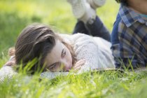 Jeune femme allongée sur une couverture de pique-nique et regardant ailleurs — Photo de stock